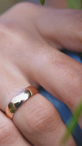 cu, slow motion: graceful young lady with shiny wedding ring on finger and french manicure holds fresh flower bouquet at ceremony extreme close view