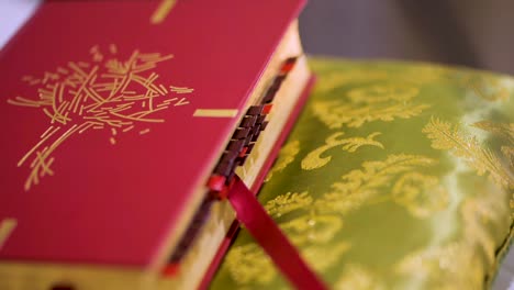 red christian bible on green religious pillow at church altar