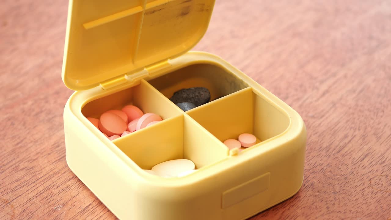 열려있는 노란색 알약 조직자와 다른 약물