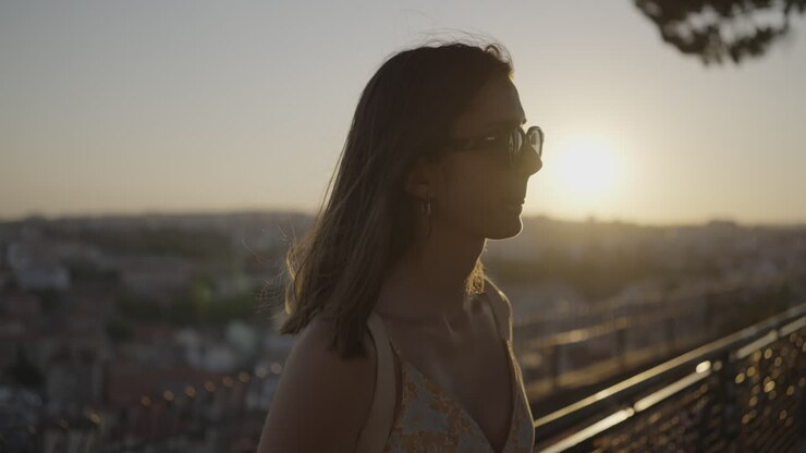 Donna che si gode il panorama della città al tramonto