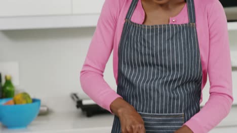 Happy-woman-cutting-vegetables-in-kitchen-