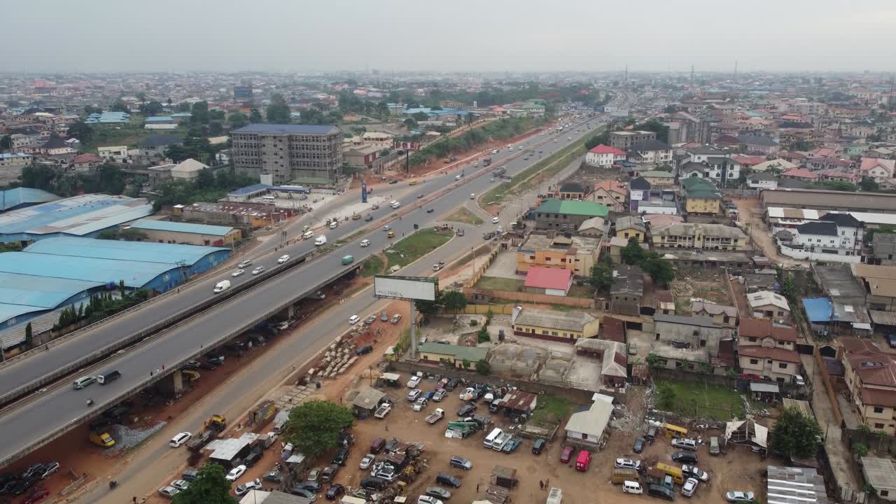 Carros e caminhão trafegando em uma ponte rodoviária de um assentamento suburbano em Lagos, Nigéria.