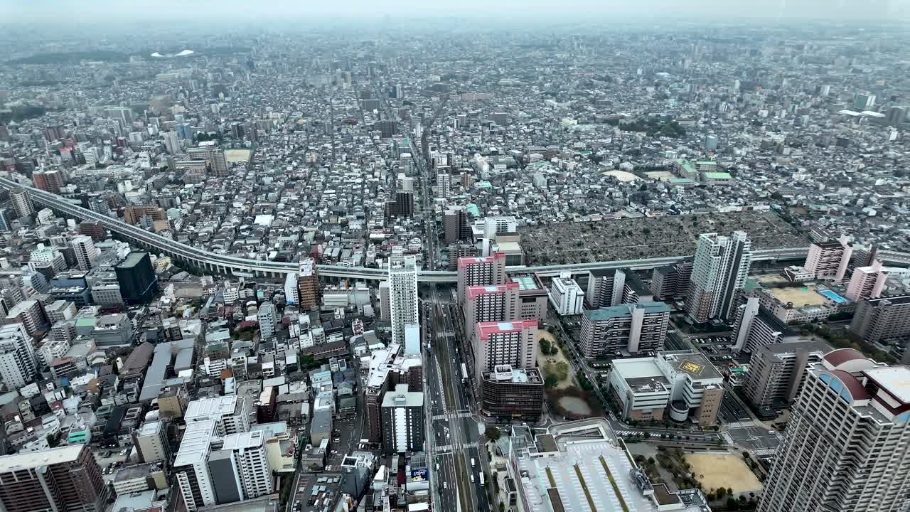 Capturing an aerial view of Osaka's bustling urban area, showcasing highways, towering buildings, and intricate city blocks in vibrant detail