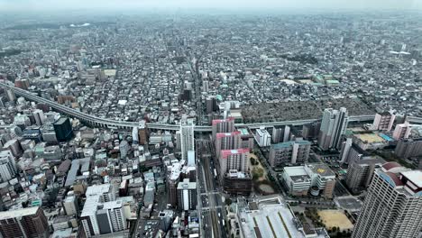 capturing an aerial view of osaka's bustling urban area, showcasing highways, towering buildings, and intricate city blocks in vibrant detail