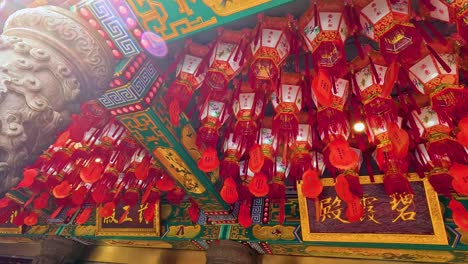 red lanterns adorn a traditional temple ceiling