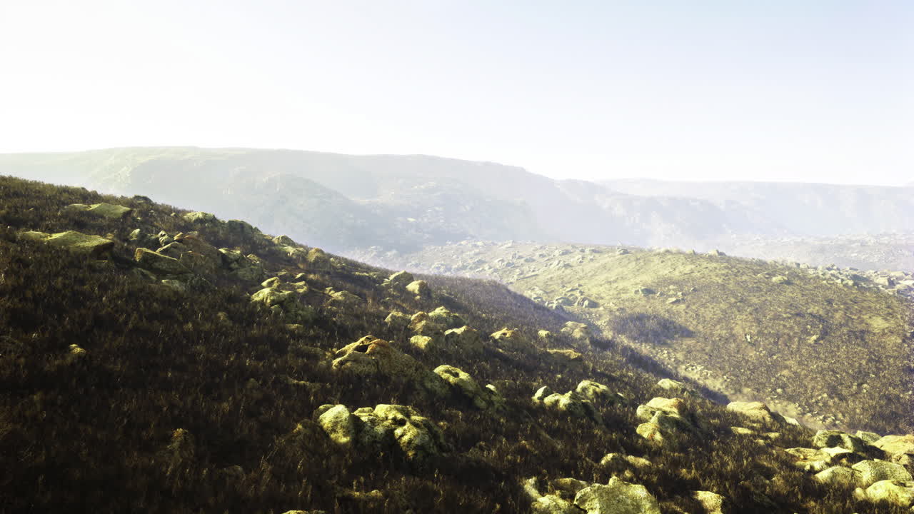 Vast landscape with rolling hills and rocky formations in clear weather