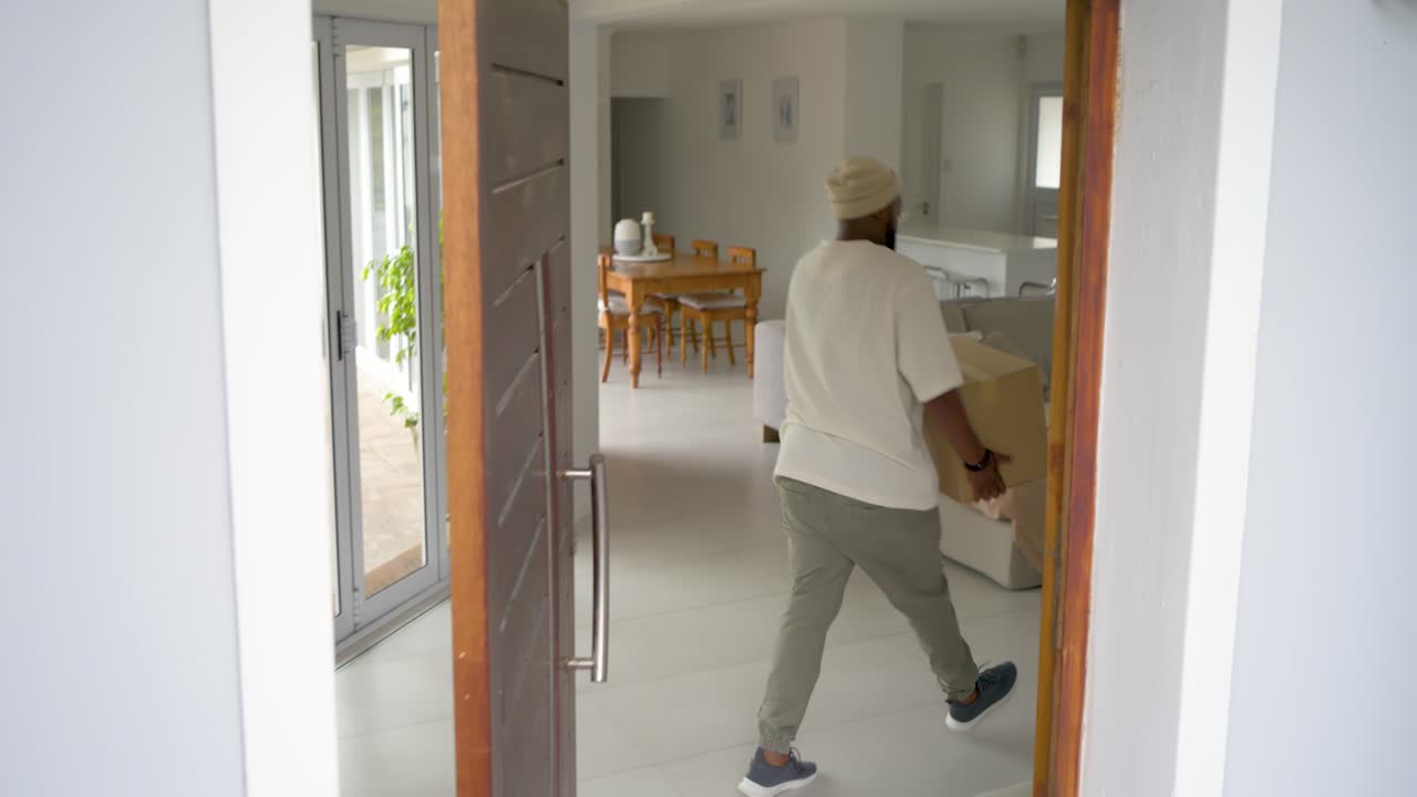 Vertical video: Seeing parcel man in beanie bringing inside home to secure taking bag, can exiting