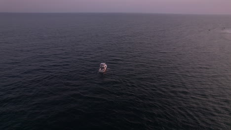 Vista-Aérea-De-Un-Barco-En-El-Agua-Durante-La-Puesta-De-Sol-En-La-Bahía-De-Narragansett,-Rhode-Island