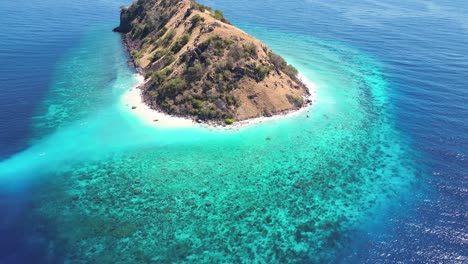 drone video over a small island surrounded by coral reefs