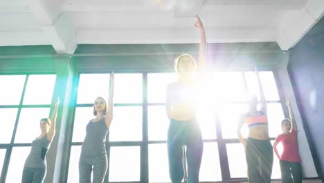 women practicing yoga poses in a bright studio