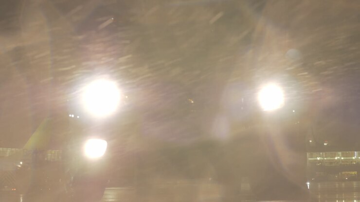 Car headlights flashing through the storm