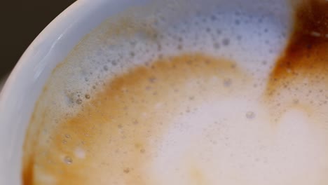 fotografía macro de un capuchino, panorámica a la izquierda, mostrando su textura y burbujas en italia
