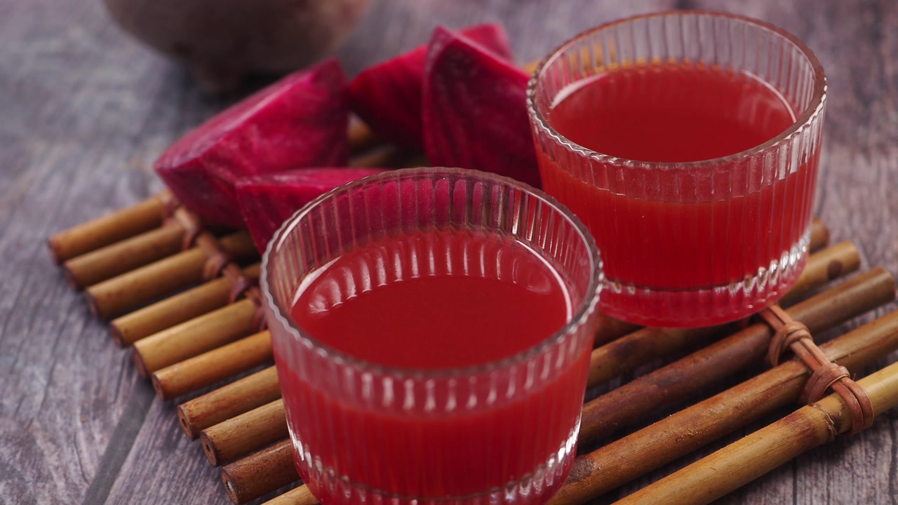 Two Glasses of Healthy Beetroot Juice on a Rustic Wooden Table