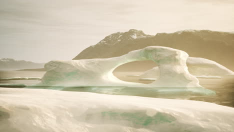 a large iceberg in the arctic with a mountain in the background