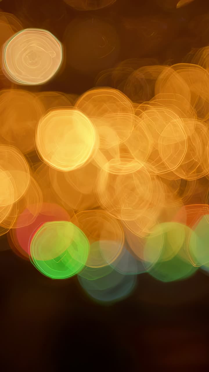 Vertical video: Moving bokeh lights drifting, sliding over at night during frame shifts with facets