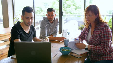 ejecutivos discutiendo sobre la computadora portátil en la cafetería de la oficina 4k