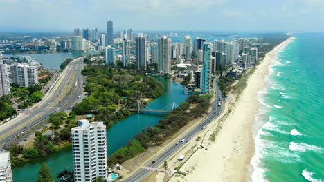 Looking-north,drone-footage-of-Beaches,-Luxury-apartments-,-with-gentle-waves,-golden-beaches