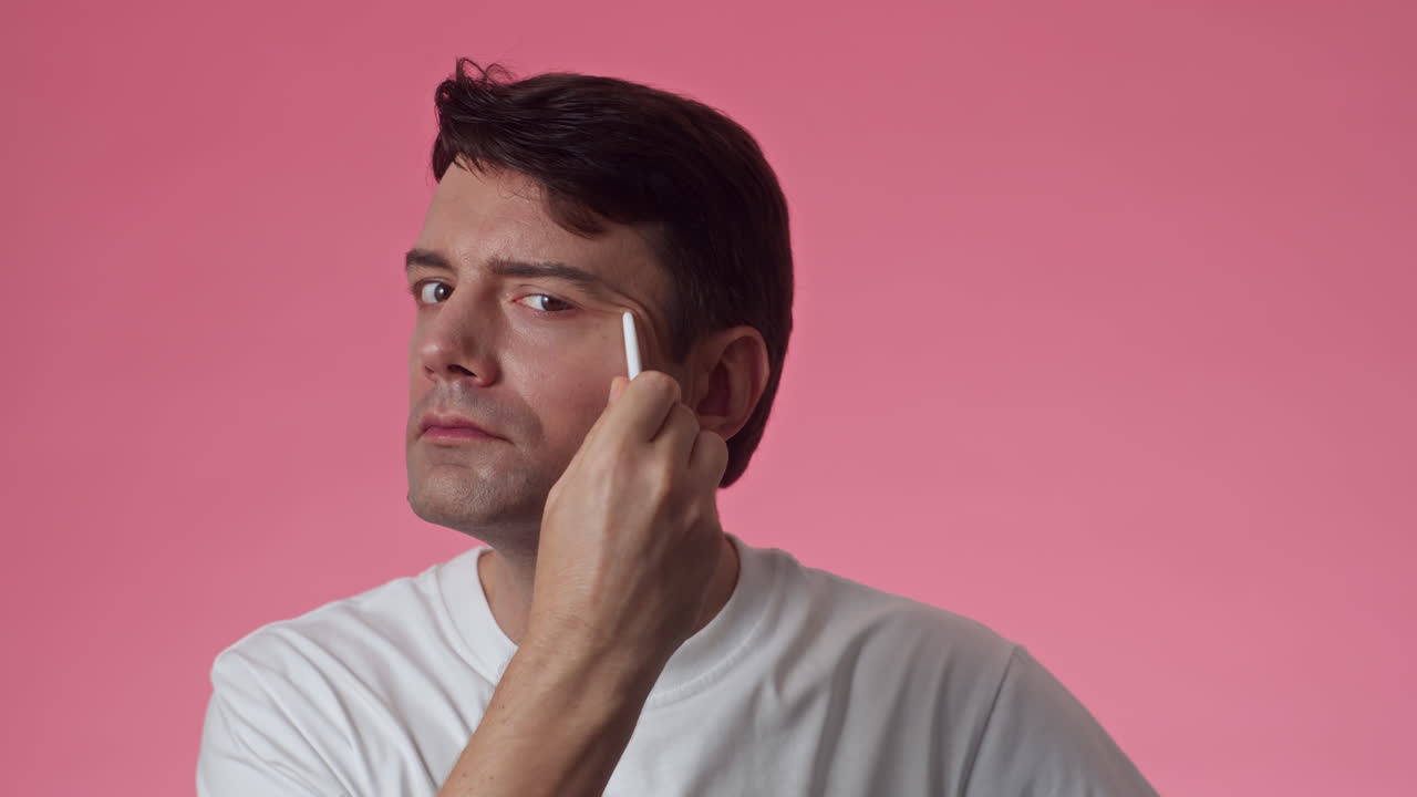 Middle-aged Man Using Gua Sha during Skin Care Procedure
