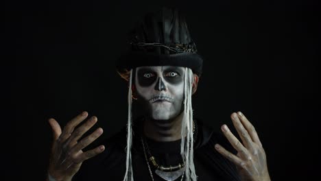 Scary-guy-in-carnival-costume-of-Halloween-skeleton-against-black-background.-Man-skull-makeup