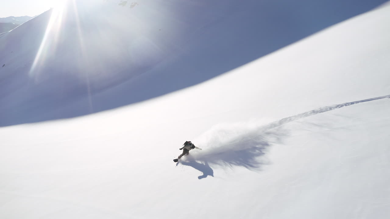 fpv drone aéreo sigue la cámara de snowboarder masculino girar mantequilla polvo de sueño abierto nieve fresca correr épico paso de vail colorado