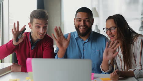 jóvenes sonrientes teniendo una conversación a través de la computadora portátil.