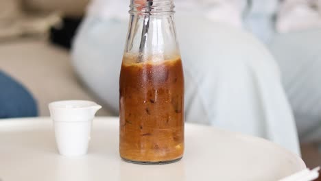 sequence of iced coffee being poured into cup