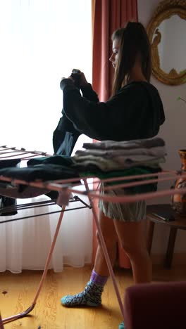 mujer secando ropa en casa