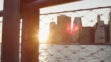 Manhattan-Skyline-Bei-Sonnenuntergang-Durch-Drahtzaun-Betrachtet