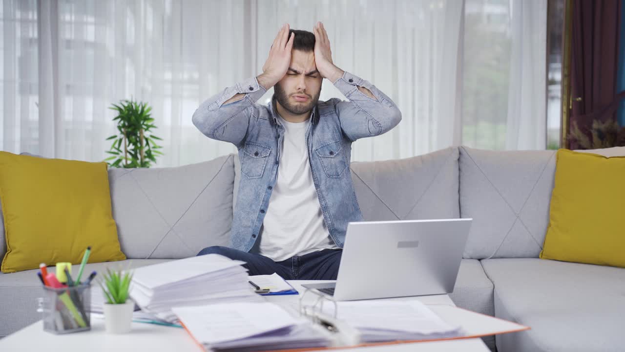 Empresário freelancer cansado, trabalhando e sofrendo de dor de cabeça.