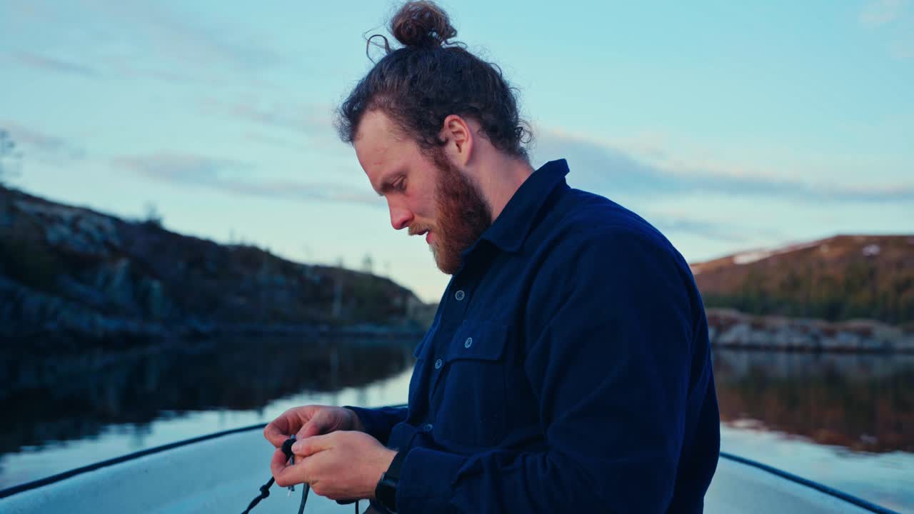 A Man Prepares a Fishing Line on a Calm Evening at Lake Reinsjøen in Åfjord, Trøndelag, Norway - Close Up