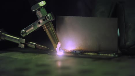 Laser-welding-machine-with-hand-hold-gun.-Laser-welding-is-shown-in-close-up.