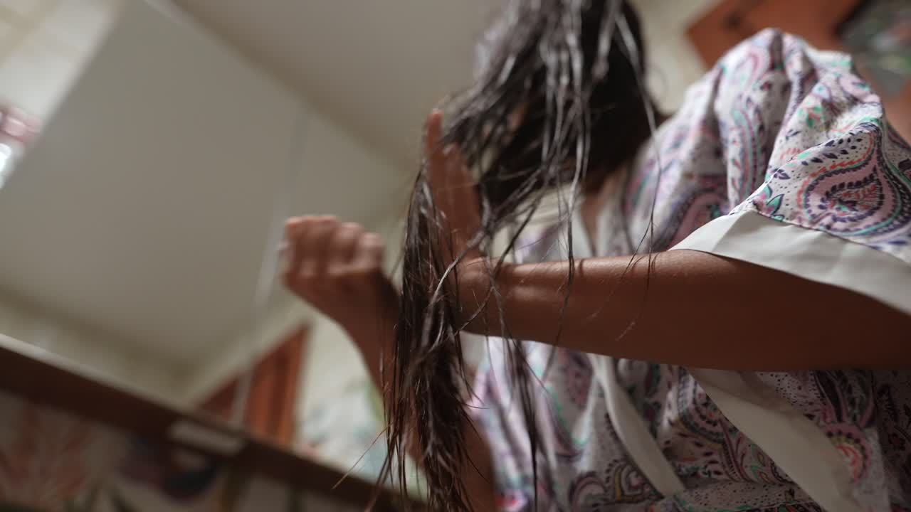 mujer secándose el cabello en el baño