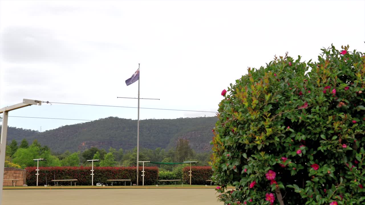 Australian flag waving over the Wisemans Ferry bowling club green, New South Wales, Australia