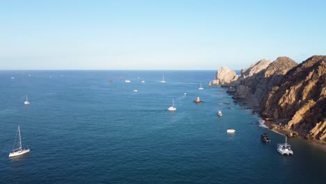 many boats in the sea, with the horizon in the background, next to mountains