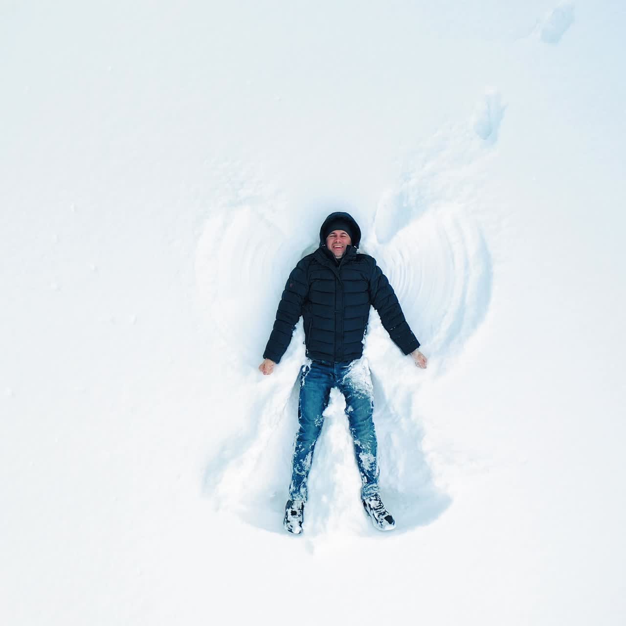 Adult man making snow angels