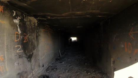 drone flies over ruined building where airsoft sport is practiced and several people dressed in military equipment