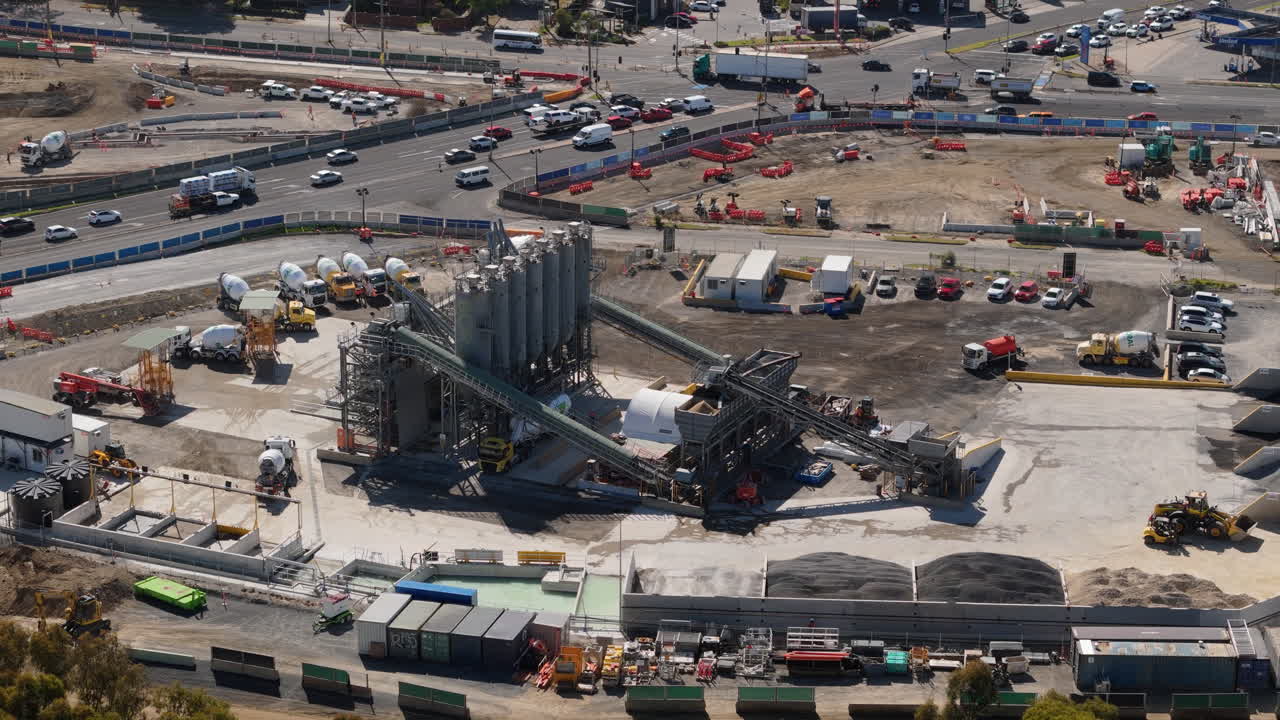 Luftaufnahme einer großen Betonmischanlage und einer belebten Straße.