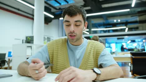 young handsome man talking on video call in office