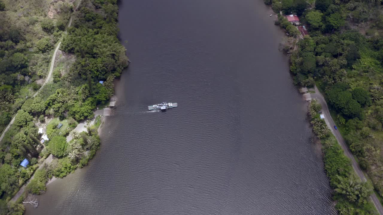 un ferry transporta automóviles de un lado de un río al otro lado durante el día