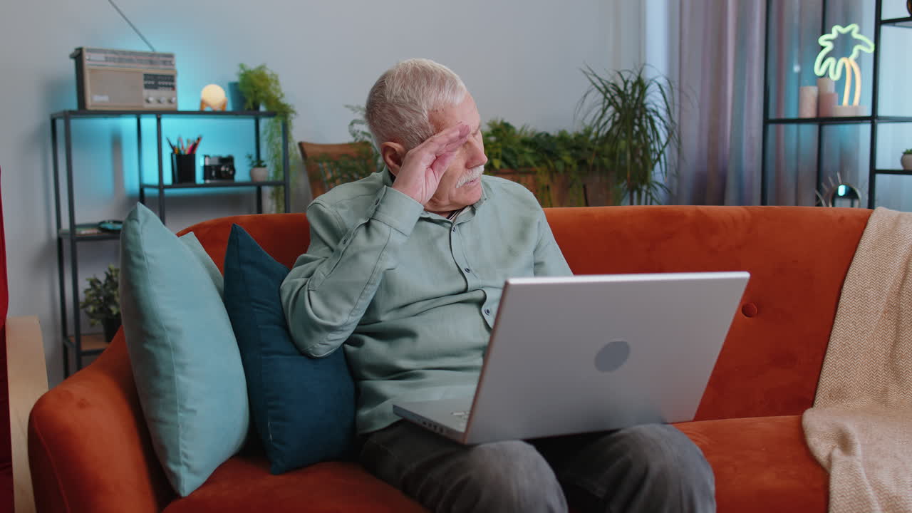 Tired senior man freelancer use laptop suffering from headache problem tension and migraine stress