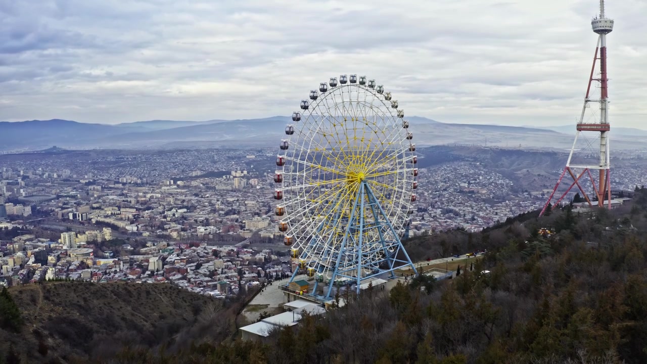 Roda-gigante do Parque Mtatsminda com vista panorâmica da cidade de Tbilisi na Geórgia. Imagem de drone