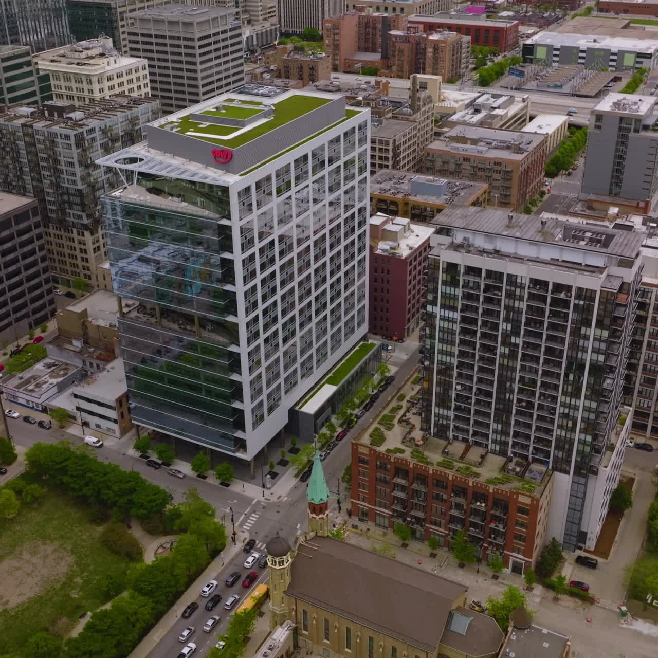 Flying slow over the tops of Chicago buildings at daytime. Lots of cars quickly moving by the streets of metropolis. Aerial perspective
