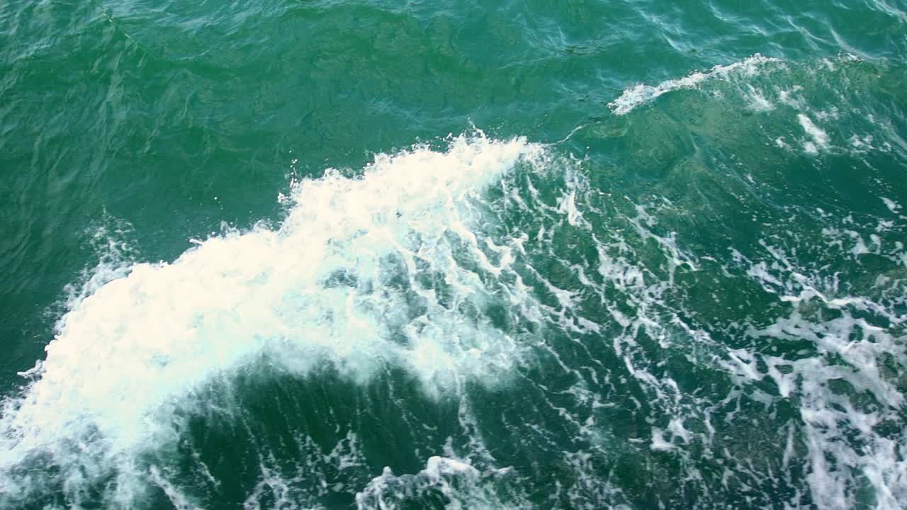 긴 꼬리 보트가 낮에 태국 끄라비 아오낭 해변을 따라 지나갈 때 생성된 잔물결 위로 높은 각도로 촬영