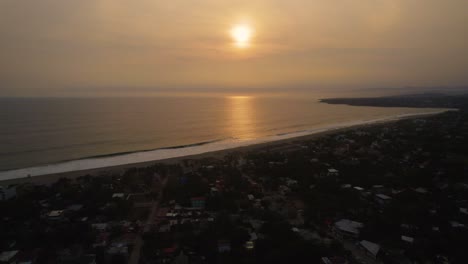 Toma-Aérea-Hacia-Atrás-Con-La-Puesta-De-Sol-Sobre-El-Océano-En-Puerto-Escondido