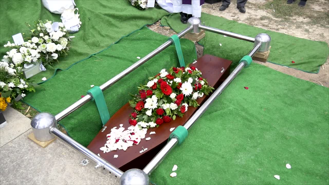 captura de pantalla de un ataúd funerario en un coche fúnebre o capilla o entierro en el cementerio