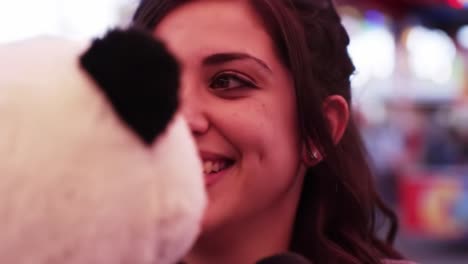 a joyful moment captured with a panda plush toy, highlighting the vibrant atmosphere of fun and excitement at a carnival or fairground