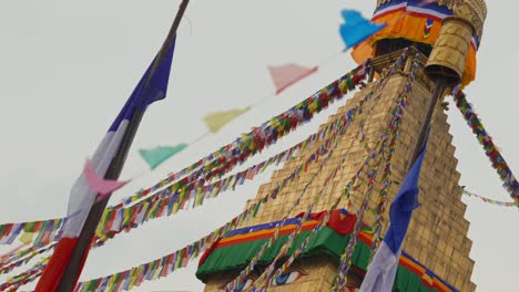 close up clip of holy temple in kathmandu, nepal showing layers of detailed decoration and multicoloured prayer flags