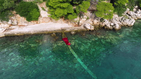 Top-View-Of-A-Woman-Swimming-In-Red-Dress-On-Adriatic-Sea