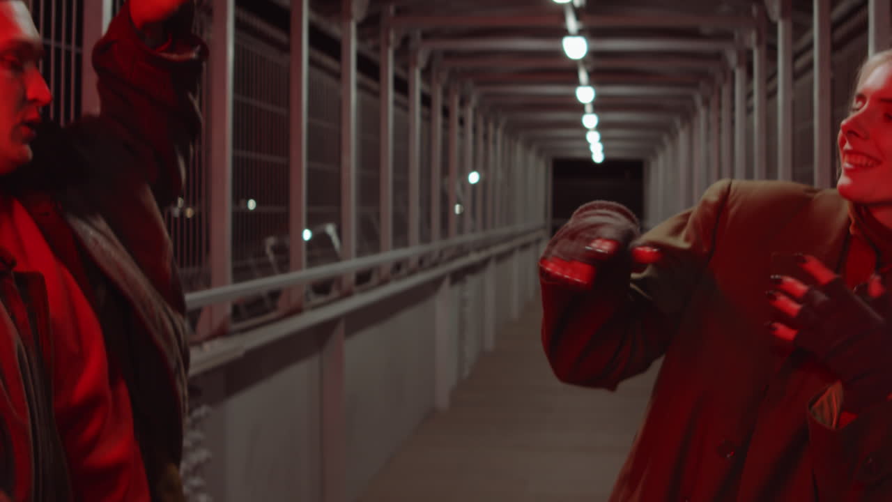 밤에 보행자 다리에서 춤을 추는 커플