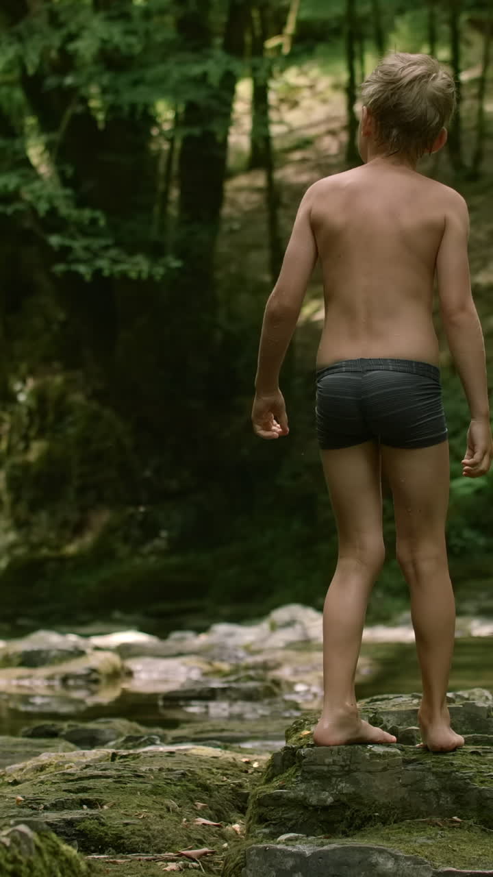 niño explorando un arroyo del bosque